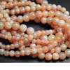 Natural White Flash Fire Peach Moonstone Smooth Round Ball Beads Strand Length is 14 Inches & Sizes from 9mm to 10.5mm approx.Each and every bead is hand polished and Shaped. 
